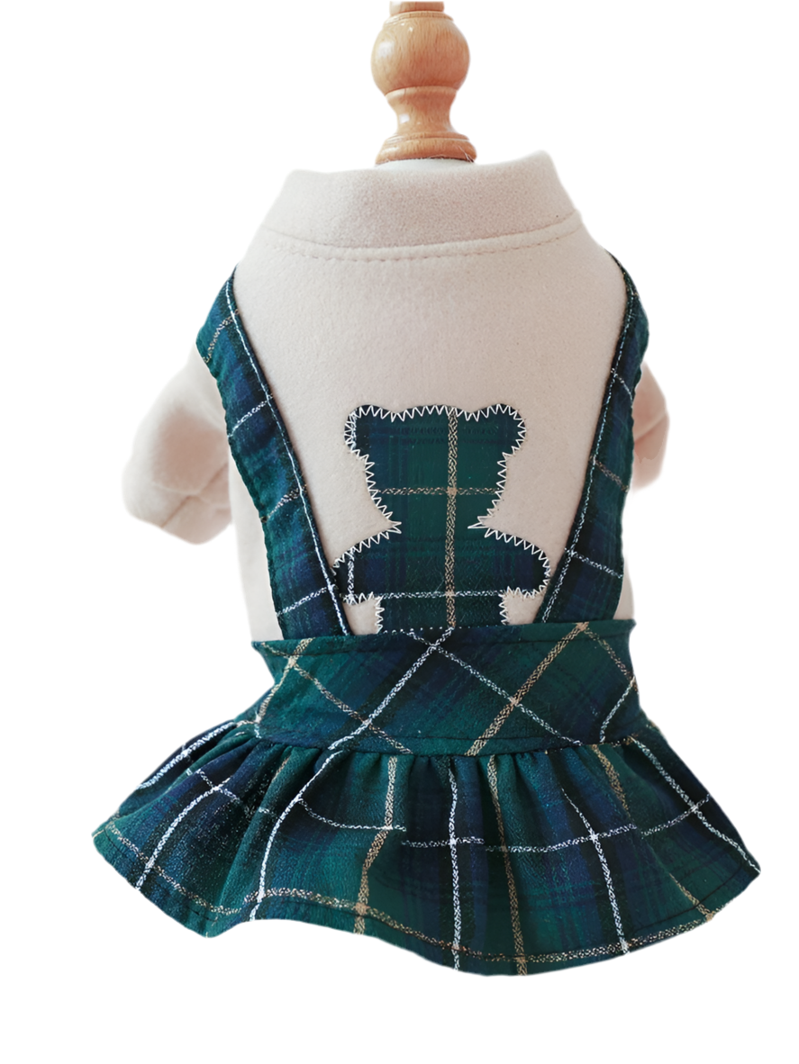 A green and blue plaid pet dress with a bear design on the back, displayed on a mannequin.